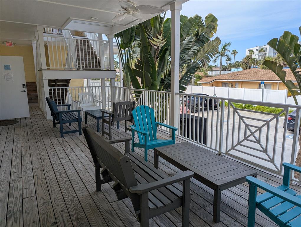 A wooden deck features several chairs and a table under a covered porch area — 6732 SARASEA CIRCLE UNIT 104C, SARASOTA, FL