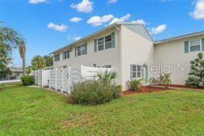 A two-story residential building with white siding, a white privacy fence, and green landscaping — 3247 38TH WAY S UNIT C, ST PETERSBURG, FL