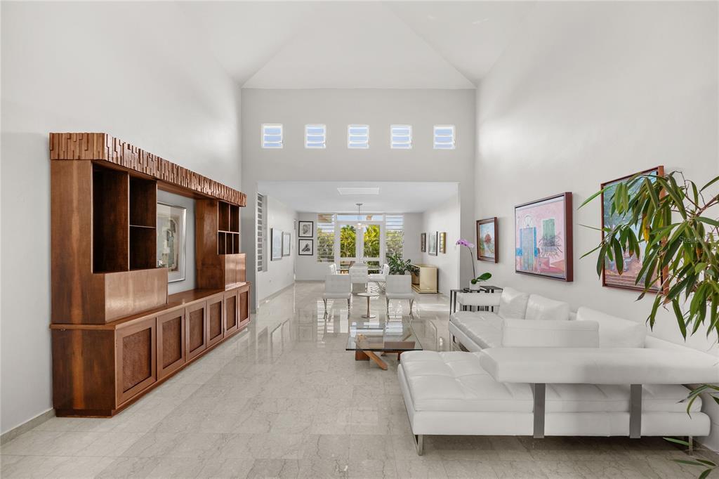 A spacious living room features high ceilings, white tile floors, and a large wooden wall unit — PASEO SAN JUAN C-8 CALLE ROGATIVA, SAN JUAN, PR
