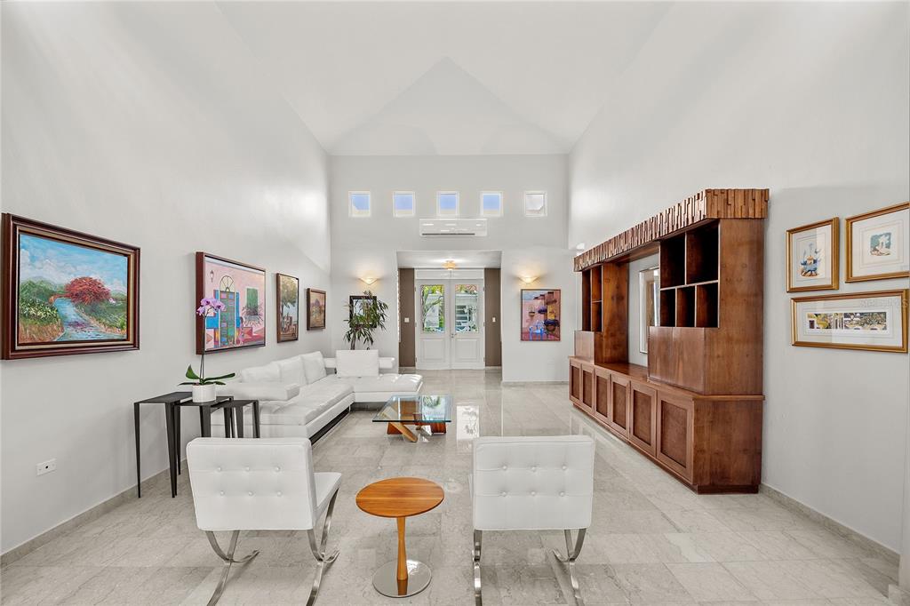 A spacious living room with white walls, tile floors, a sectional sofa, and wood cabinetry — PASEO SAN JUAN C-8 CALLE ROGATIVA, SAN JUAN, PR
