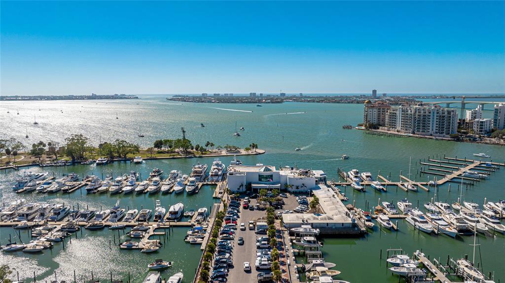An aerial view shows a marina with numerous docked boats and a central building — 1350 MAIN STREET UNIT 1503, SARASOTA, FL
