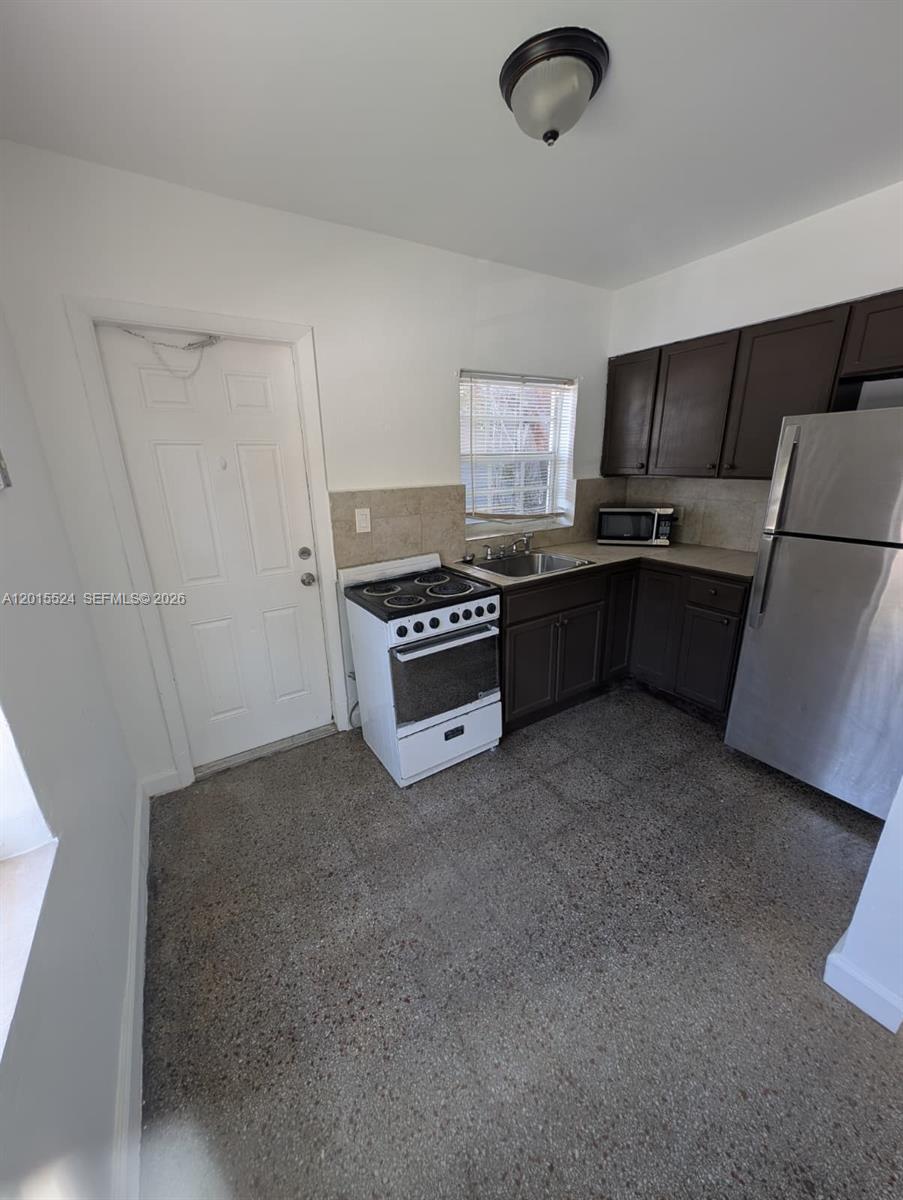 A kitchen features dark brown cabinets, stainless steel appliances, and a white stove — 2316 Madison St # 19, Hollywood FL 33020, HOLLYWOOD, FL