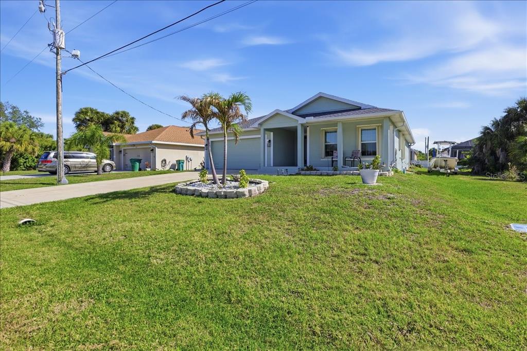 A light green single-story house with a palm tree in the front yard — 138 SUNNY WAY, ROTONDA WEST, FL