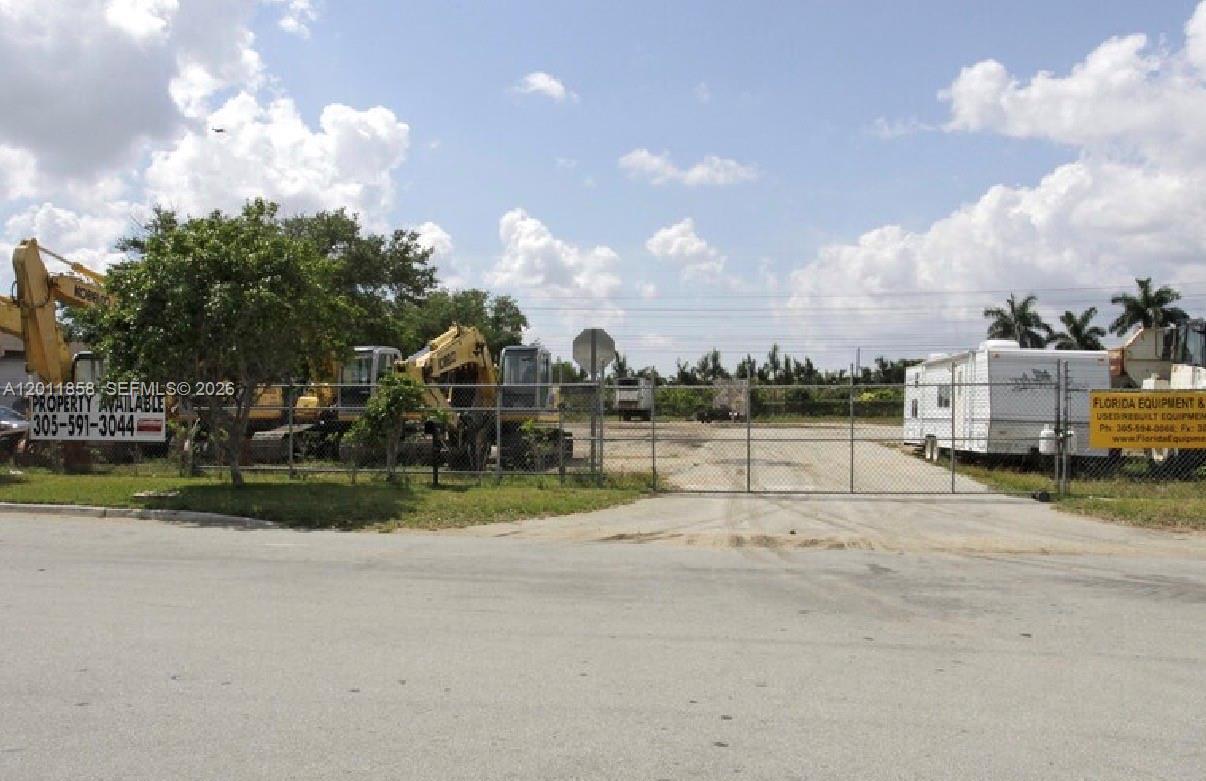 A fenced outdoor lot contains several pieces of heavy construction equipment and a mobile office — 8322 NW 64, Miami FL 33166, MIAMI, FL