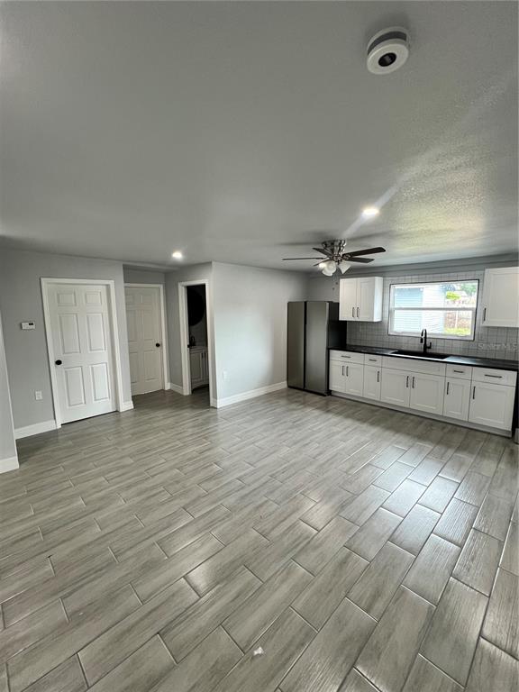 A kitchen with white cabinets, stainless steel appliances, and gray wood-look tile flooring — 2309 21ST AVENUE W, BRADENTON, FL