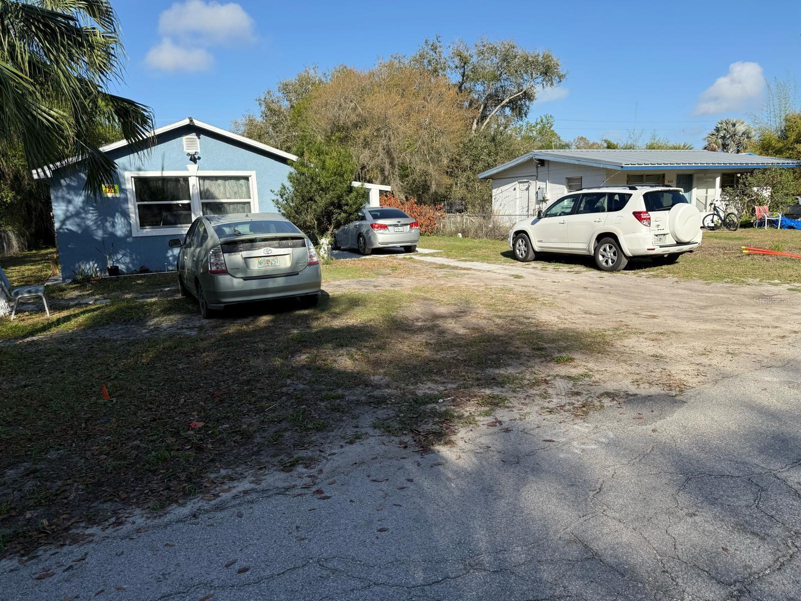 Two houses sit on a dirt lot with three parked cars in front — 414 Spring Avenue, FL 34266, FL