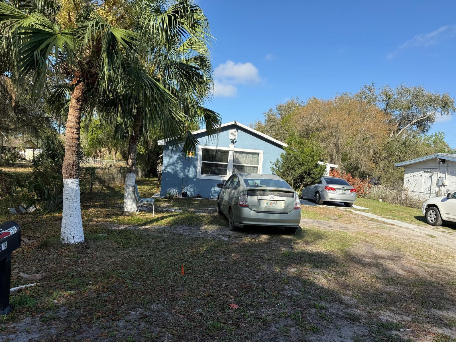 A blue house with a palm tree in the front yard and parked cars — 414 Spring Avenue, FL 34266, FL