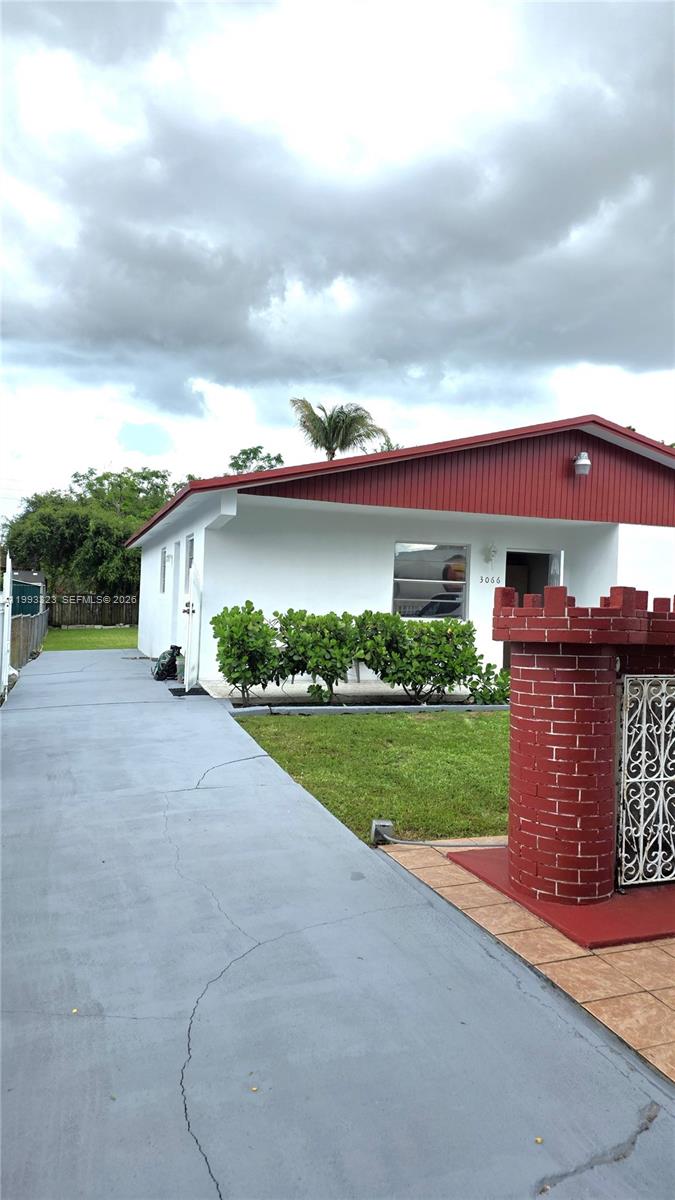A single-story house features a white exterior, a red roof, and a red brick pillar — 3066 NW 28th St, Miami FL 33142, MIAMI, FL