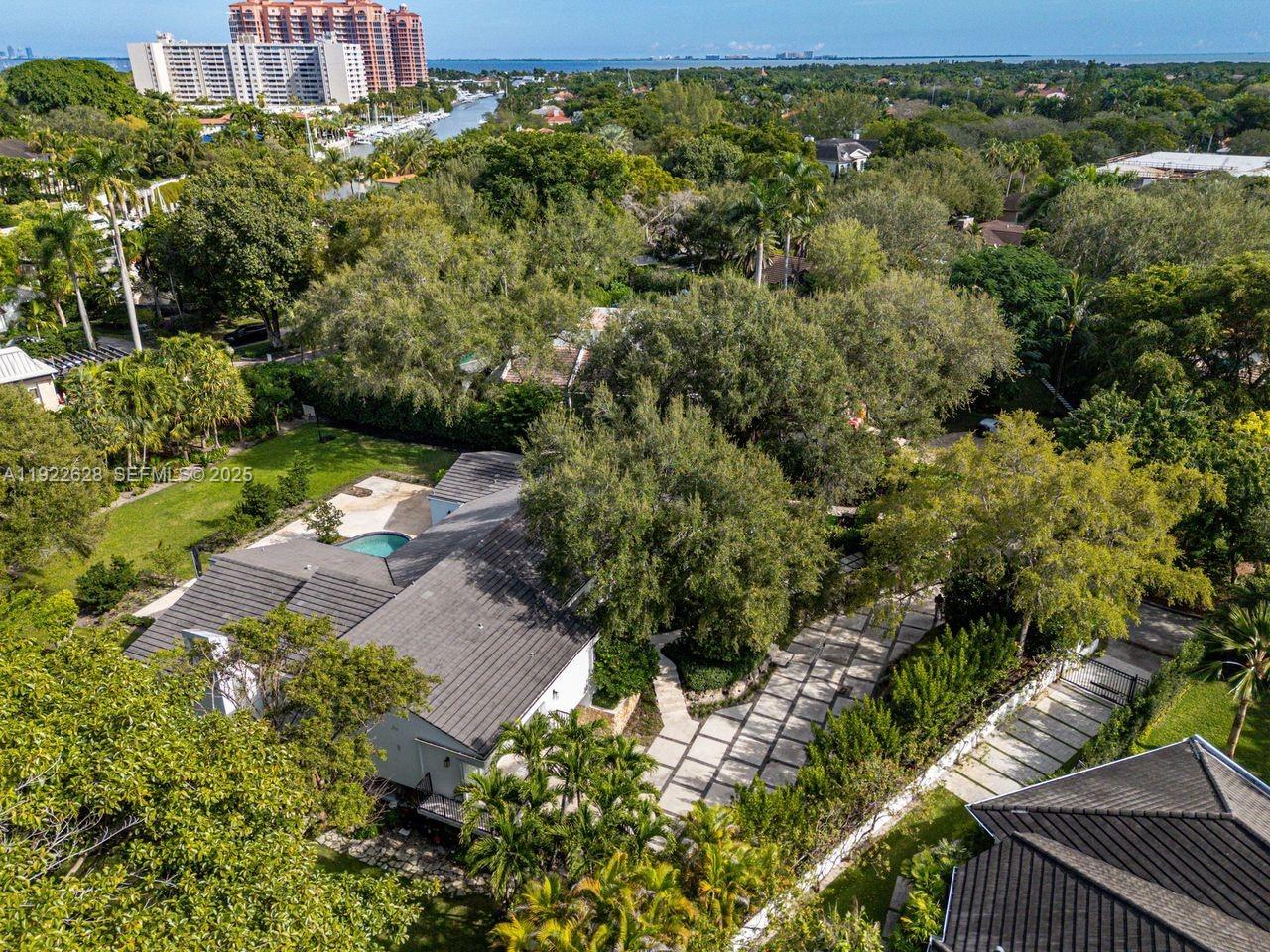 An aerial view shows a house with a pool, a paved driveway, and lush landscaping — 7000 Robles St, Coral Gables FL 33143, CORAL GABLES, FL
