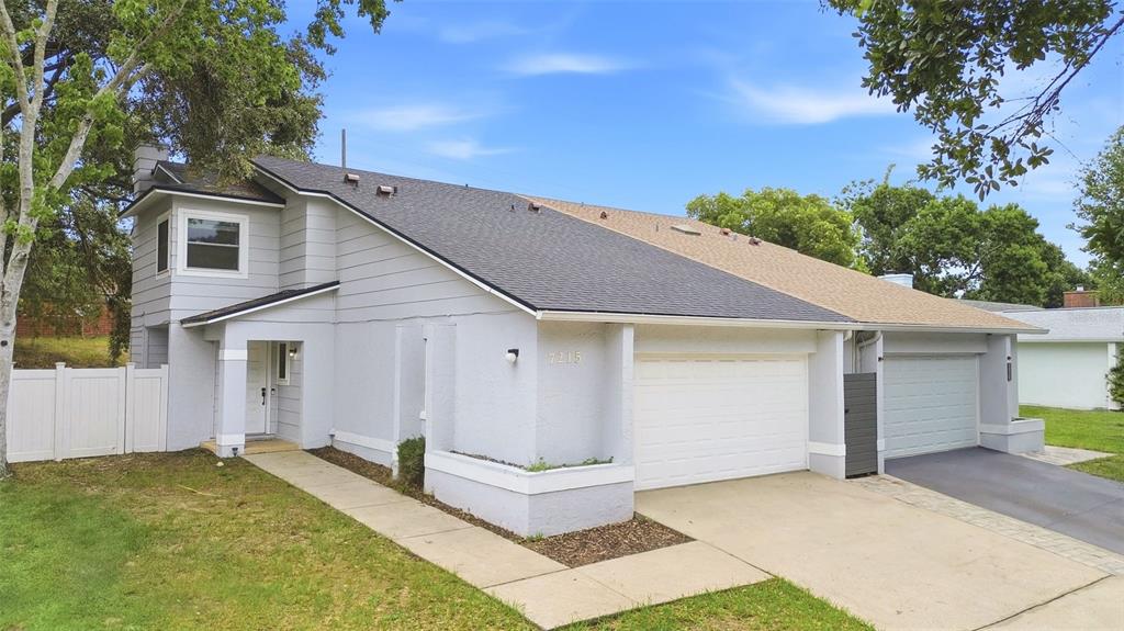 A light gray two-story duplex with a white garage and a concrete walkway — 7215 HARBOR HEIGHTS CIRCLE, ORLANDO, FL