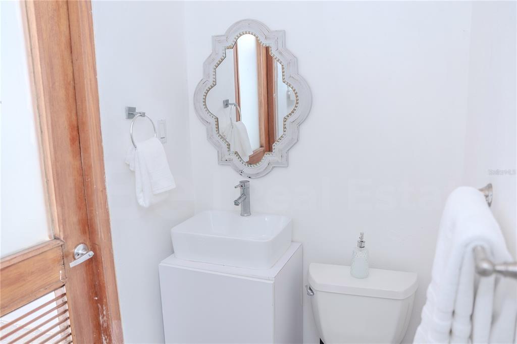 A small bathroom features a white vessel sink, a decorative mirror, and a toilet — 152 SOL STREET, OLD SAN JUAN, PR