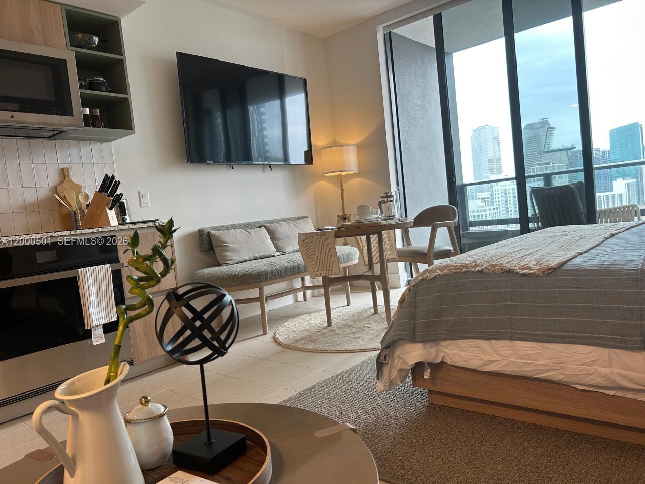 A studio apartment features a kitchen, dining area, and bed with a city view — 159 NE 6 ST ST # 3206, Miami FL 33132, MIAMI, FL