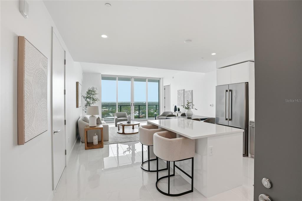 A modern open-concept apartment features a kitchen island, living area, and floor-to-ceiling windows — 400 CENTRAL AVENUE UNIT 2008, ST PETERSBURG, FL
