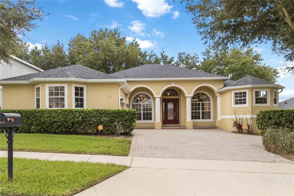 A single-story house with a yellow stucco exterior, arched entryway, and a paved driveway — 513 PARKSIDE POINTE BOULEVARD, APOPKA, FL