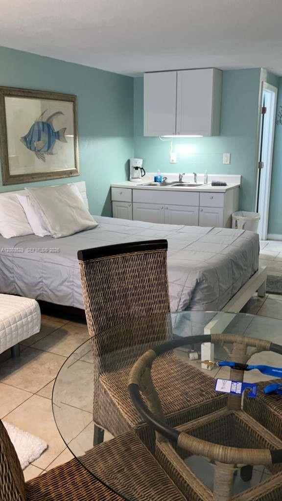 A bedroom features a bed, a small kitchenette with white cabinets, and a glass table — 3501 S ATLANTIC AVE # G140, Daytona FL 32118, DAYTONA, FL