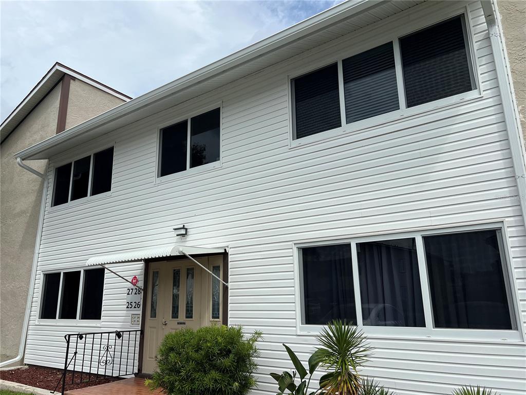 A two-story building with white horizontal siding and a central entrance under a small awning — 22481 WESTCHESTER BOULEVARD UNIT B27, PUNTA GORDA, FL