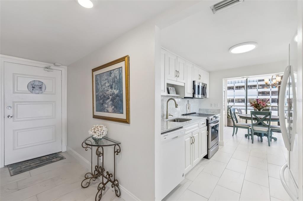 A bright hallway features white tiled floors, a mirrored closet, and a white interior door — 2900 N ATLANTIC AVENUE UNIT 1106, DAYTONA BEACH, FL