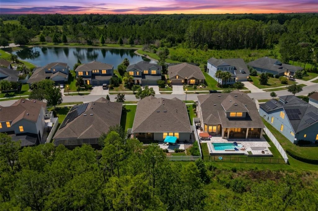 A covered patio features wicker chairs, a ceiling fan, and a view of a backyard — 2902 LONG BOW WAY, ODESSA, FL