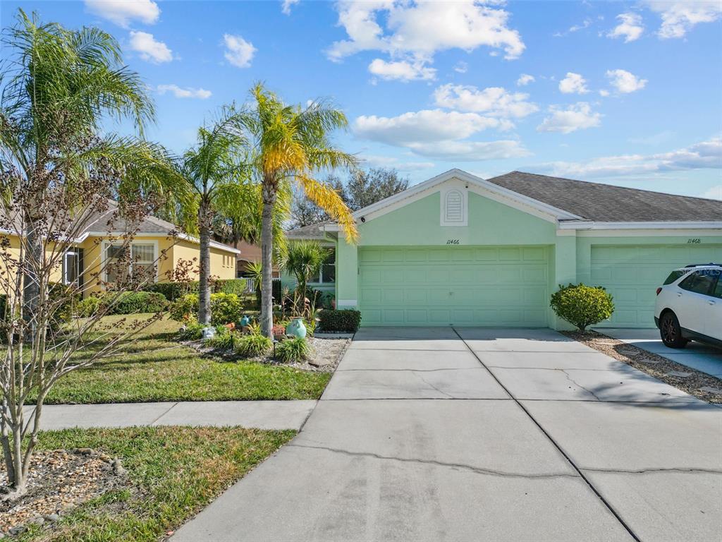 A light green single-story house with a two-car garage and a concrete driveway — 11466 CAPTIVA KAY DRIVE, RIVERVIEW, FL