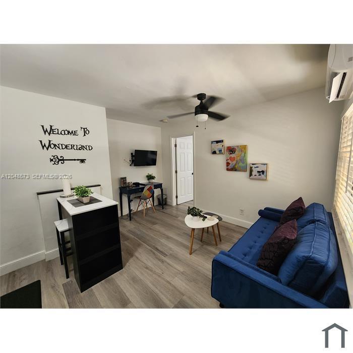 A bedroom features a wall-mounted air conditioner, a telescope on a tripod, and a lamp — 2032 NE 26th St # 3, Wilton Manors FL 33305, WILTON MANORS, FL