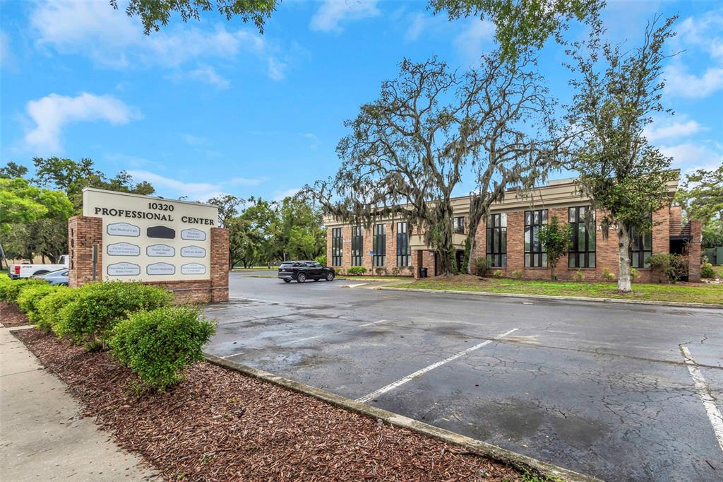 A brick professional center building stands behind a parking lot with a directory sign — 10320 N 56TH STREET UNIT 100, TEMPLE TERRACE, FL