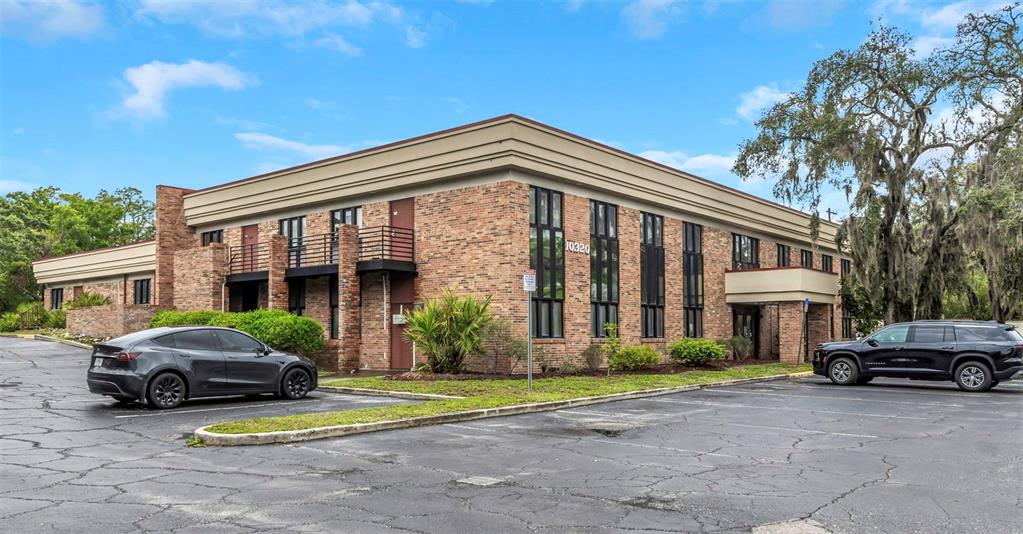 A two-story brick office building with a parking lot and two parked cars — 10320 N 56TH STREET UNIT 100, TEMPLE TERRACE, FL