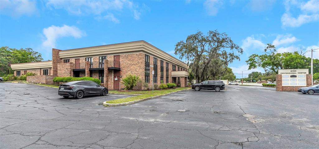 A two-story brick office building features a parking lot and a professional center sign — 10320 N 56TH STREET UNIT 100, TEMPLE TERRACE, FL