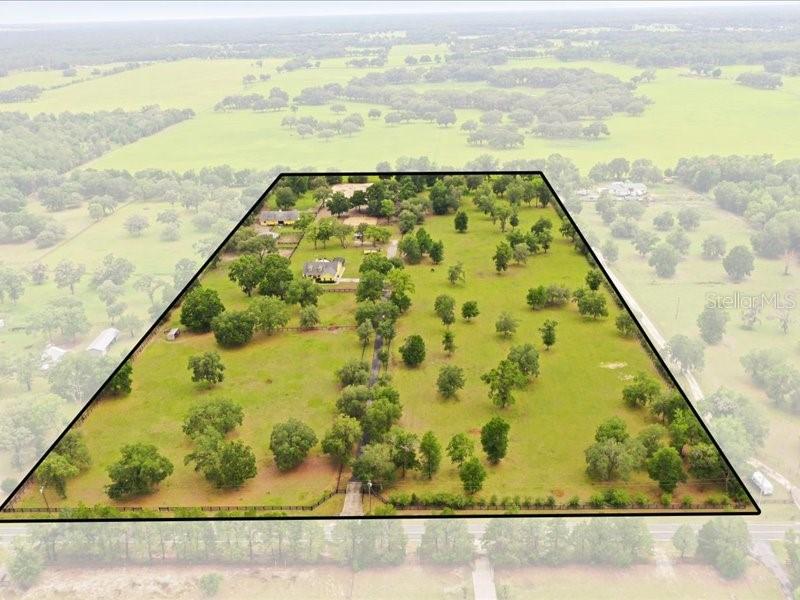 An aerial view shows a large, grassy property with scattered trees and a house — 19950 SW 5TH PLACE, DUNNELLON, FL