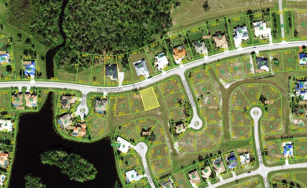 This is an aerial map showing residential lots, streets, and houses in a suburban neighborhood — 24411 RIO TOGAS ROAD, PUNTA GORDA, FL