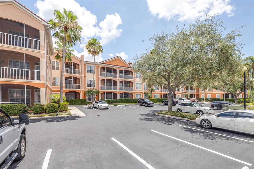 An exterior view of a multi-story apartment complex with a parking lot in the foreground — 5000 CULBREATH KEY WAY UNIT 1-309, TAMPA, FL