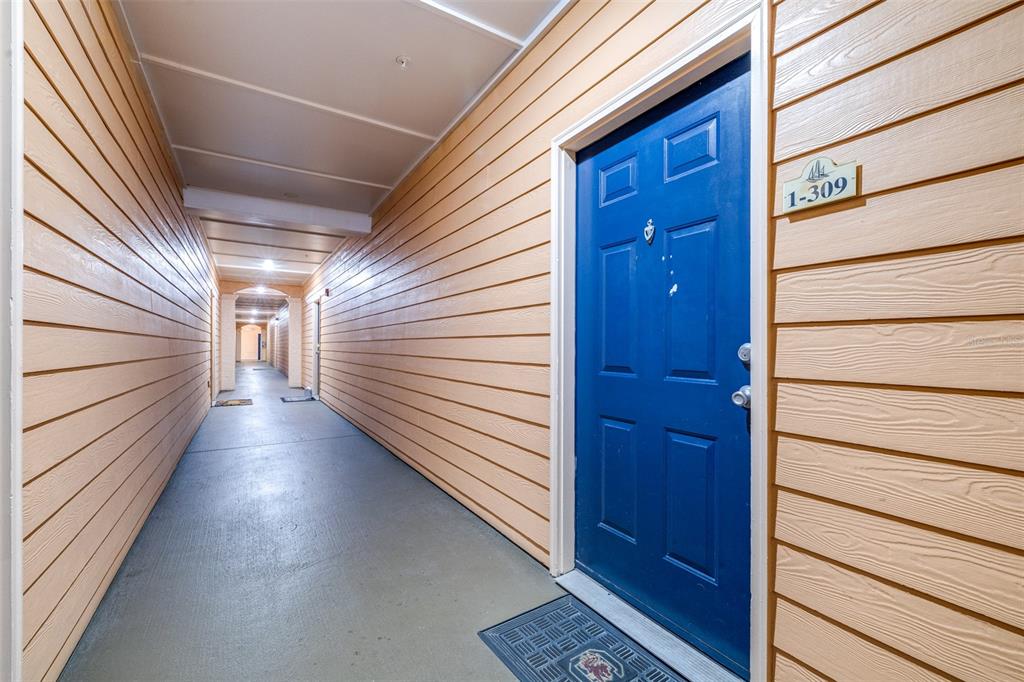 A blue apartment door with the number 1-309 is located in an outdoor hallway — 5000 CULBREATH KEY WAY UNIT 1-309, TAMPA, FL
