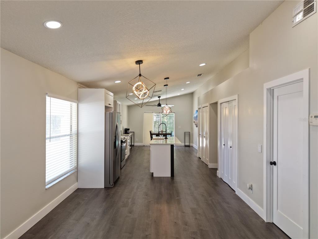 A kitchen with a center island, stainless steel appliances, and wood-look flooring — 3103 BELLINGHAM DRIVE, ORLANDO, FL