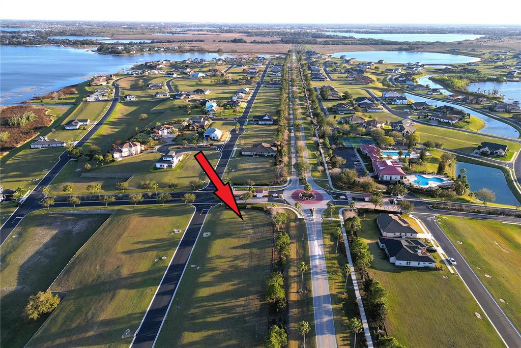 An aerial view shows a vacant residential lot situated next to a roundabout and road — 508 BONAMIA AVENUE, LAKE ALFRED, FL