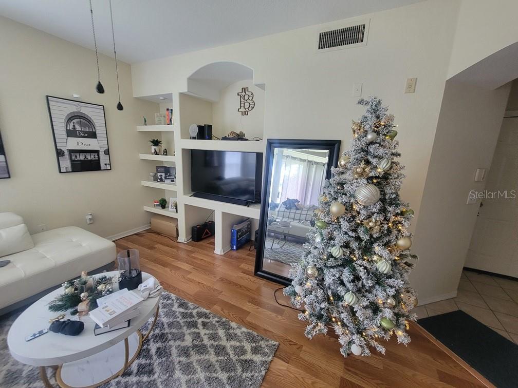 A living room features a white sofa, a coffee table, a Christmas tree, and built-in shelving — 8413 LUCUYA WAY UNIT 306, TEMPLE TERRACE, FL