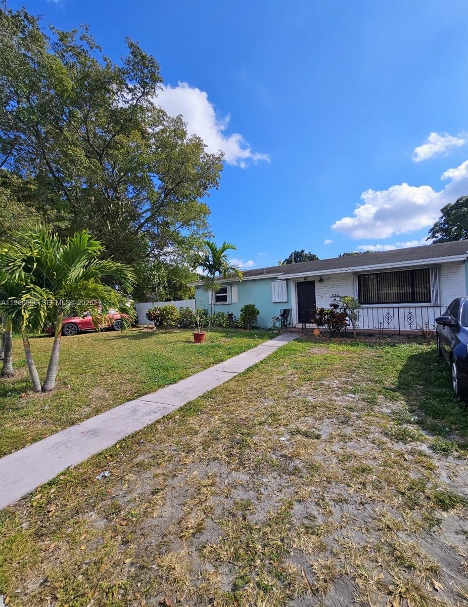 A single-story house with a light blue exterior, a front walkway, and palm trees — 1760 NW 135th St, Miami FL 33167, MIAMI, FL