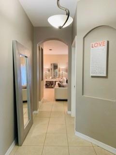 A hallway with tile flooring, a large floor mirror, and a framed sign on the wall — 4948 SW 136th Avenue, Miramar FL 33027, MIRAMAR, FL