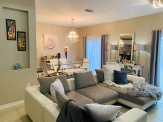 A living room with a gray sectional sofa, dining area, and wall niche with art — 4948 SW 136th Avenue, Miramar FL 33027, MIRAMAR, FL