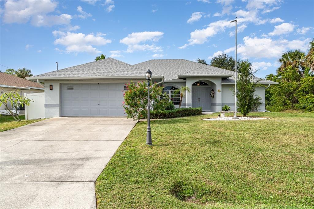A single-story house with a gray roof, a two-car garage, and a concrete driveway — 4186 YUCATAN CIRCLE, PORT CHARLOTTE, FL