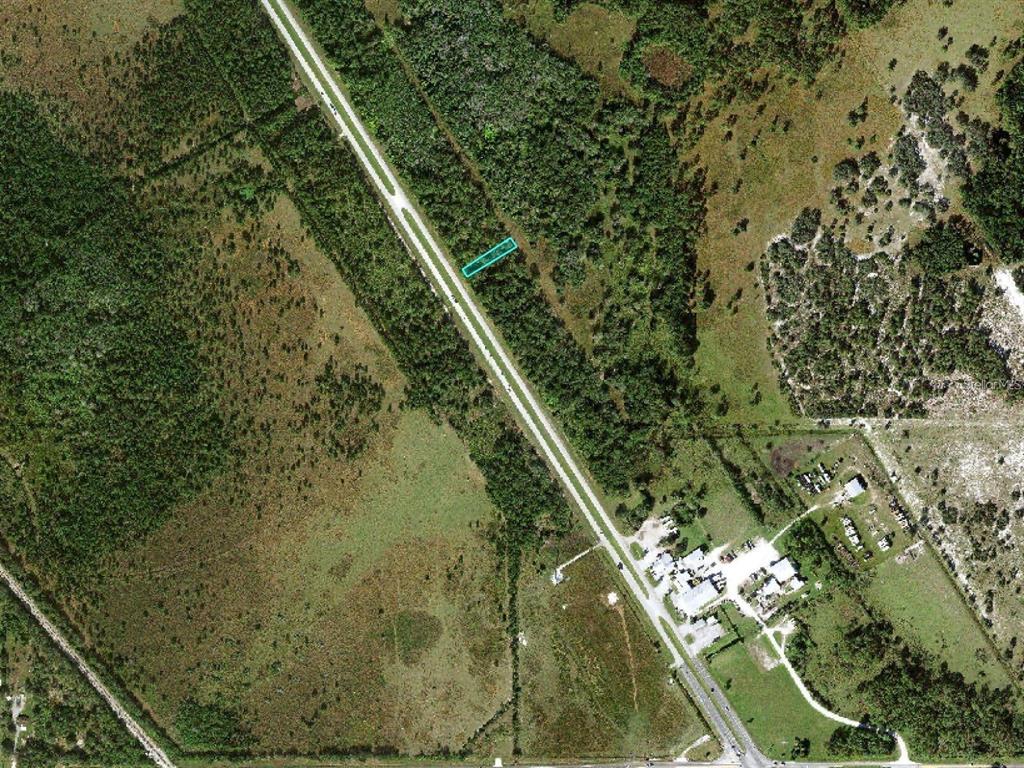 An aerial view shows a rectangular plot of land highlighted in teal along a road — US 27 HIGHWAY UNIT 517, FROSTPROOF, FL