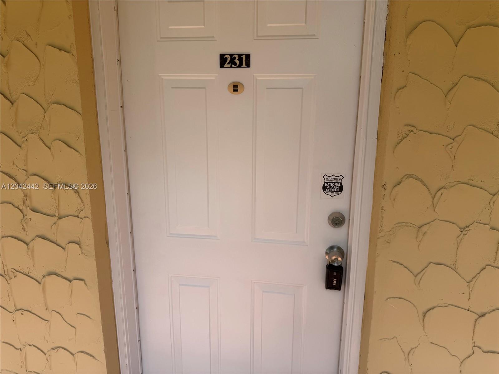 A white door with the number 231 is set into a textured, light-colored exterior wall — 8600 SW 109th Ave # 231, Miami FL 33173, MIAMI, FL