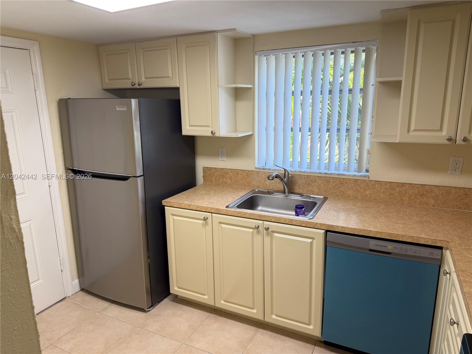 A kitchen features light-colored cabinets, a stainless steel refrigerator, a sink, and a dishwasher — 8600 SW 109th Ave # 231, Miami FL 33173, MIAMI, FL