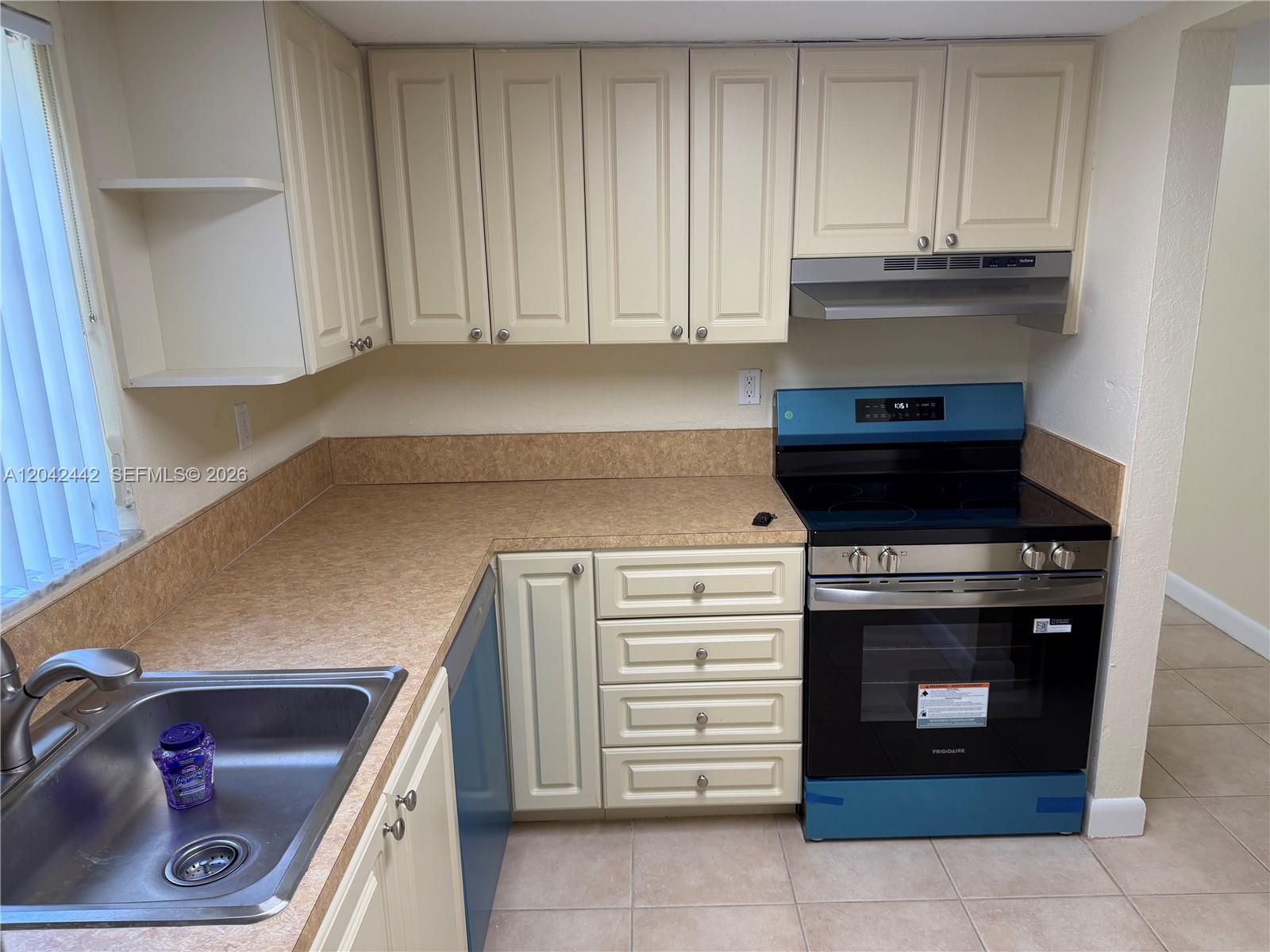 A kitchen features cream cabinets, tan laminate countertops, and a blue electric range — 8600 SW 109th Ave # 231, Miami FL 33173, MIAMI, FL