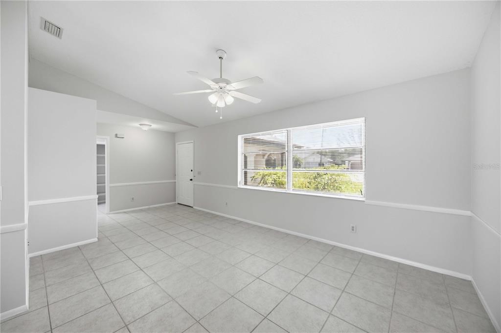 An empty room with light gray walls, tile flooring, a ceiling fan, and a window — 2221 MAURITANIA ROAD, PUNTA GORDA, FL