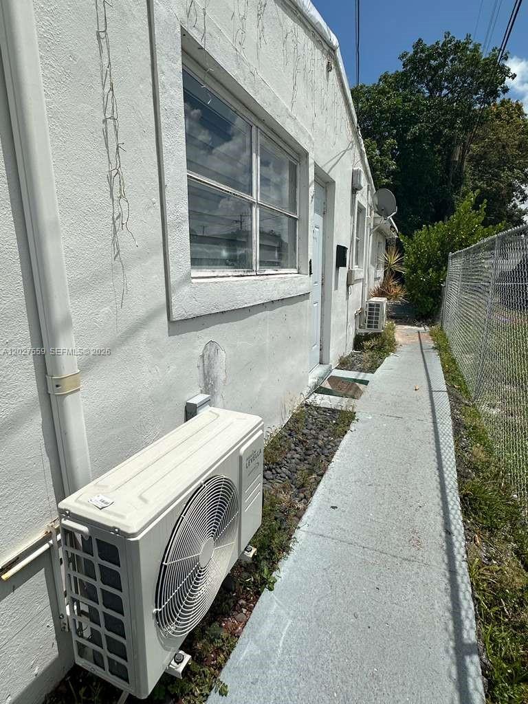 An exterior view shows a white building wall with an air conditioning unit and walkway — 685 SW 7th Ter, Dania Beach FL 33004, DANIA BEACH, FL