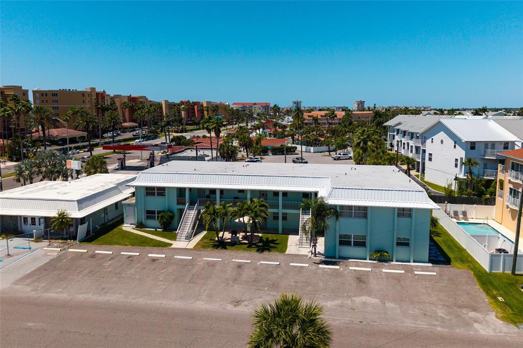 An aerial view shows a two-story teal apartment building with a parking lot in front — 10 164TH AVENUE UNIT 1, REDINGTON BEACH, FL
