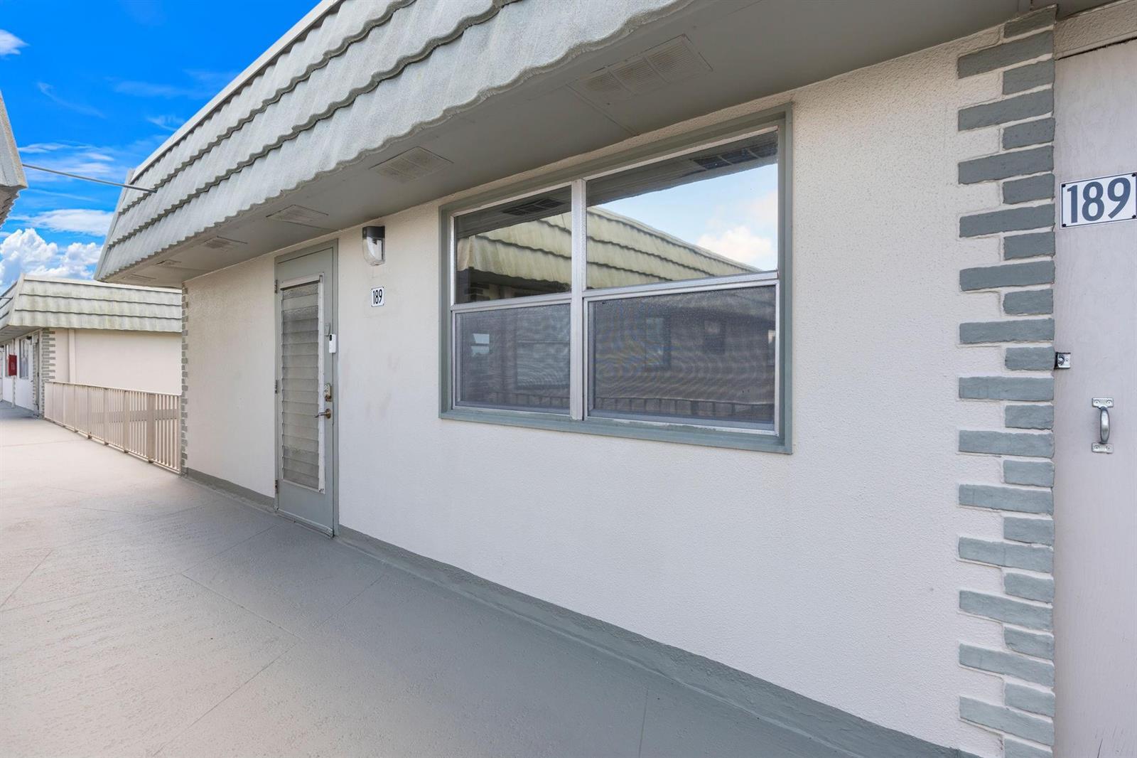 An exterior view of a building unit with a white wall, window, and door — 189 Brittany D # 189, Delray Beach FL 33446, DELRAY BEACH, FL