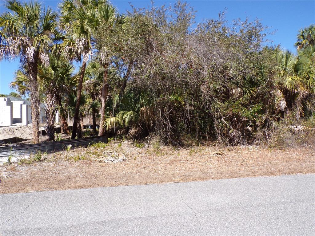 A vacant, wooded residential lot sits next to a house under construction — LAS ALMANOS AVENUE, NORTH PORT, FL