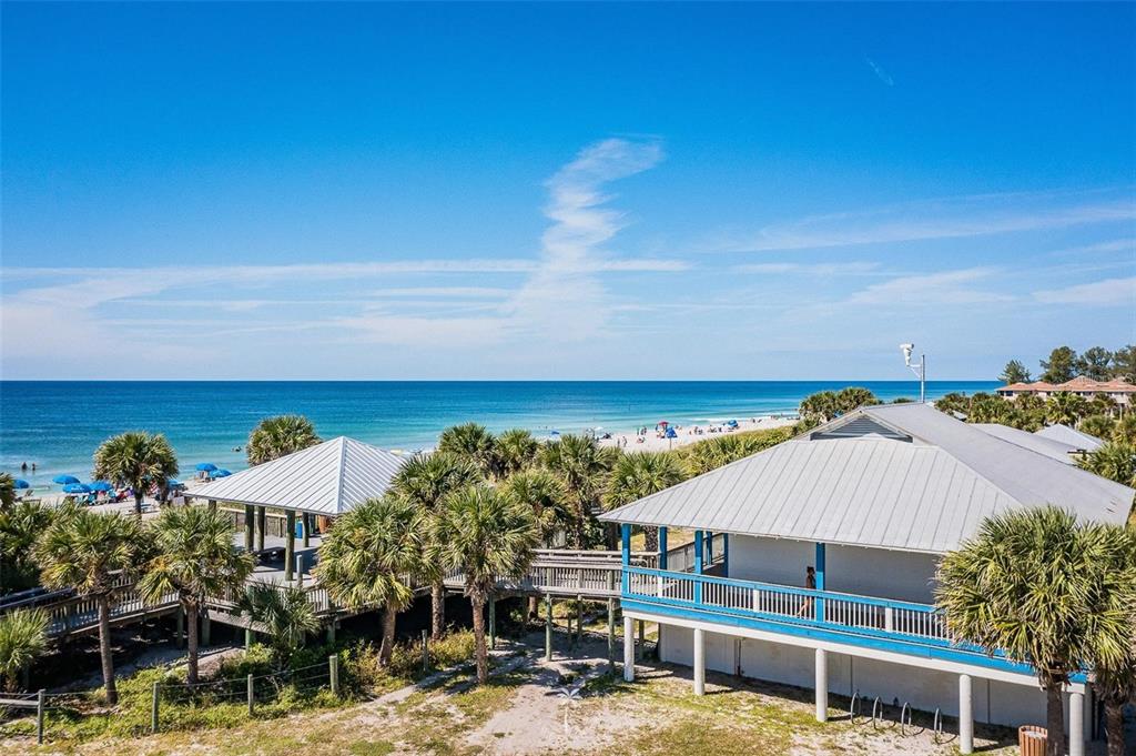 An elevated view shows two beach buildings with metal roofs surrounded by palm trees — 13362 CHAMBERLAIN BOULEVARD, PORT CHARLOTTE, FL