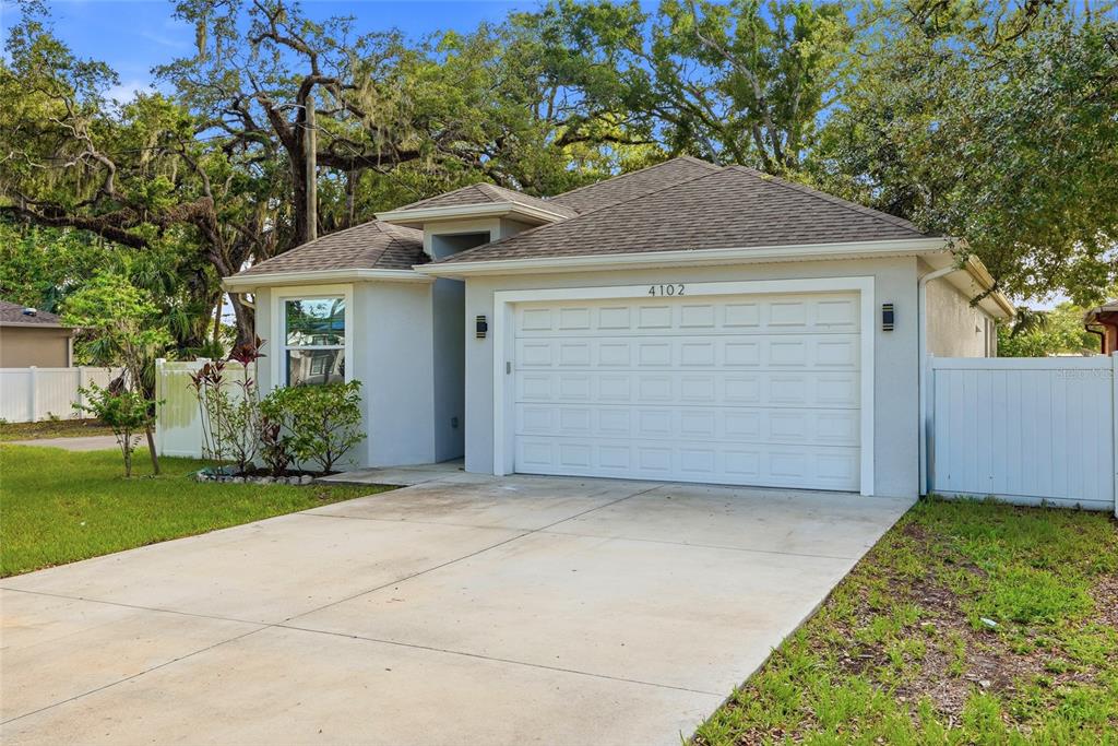 A living room with a tray ceiling and ceiling fan opens to a laundry room — 4102 N 29TH STREET, TAMPA, FL