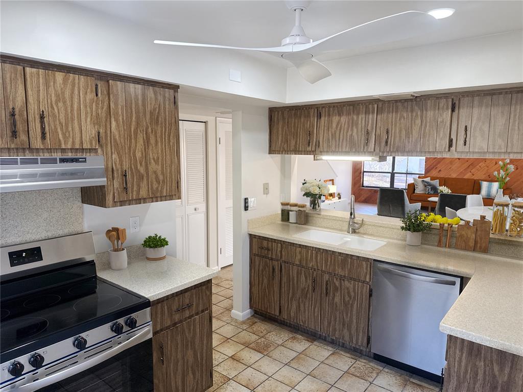 A kitchen features wood-grain cabinets, a white double sink, and a stainless steel dishwasher — 3808 NE 17TH STREET CIRCLE, OCALA, FL